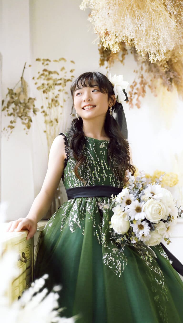 ドライフラワーに囲まれたスタジオで花束を持ち笑顔の女の子